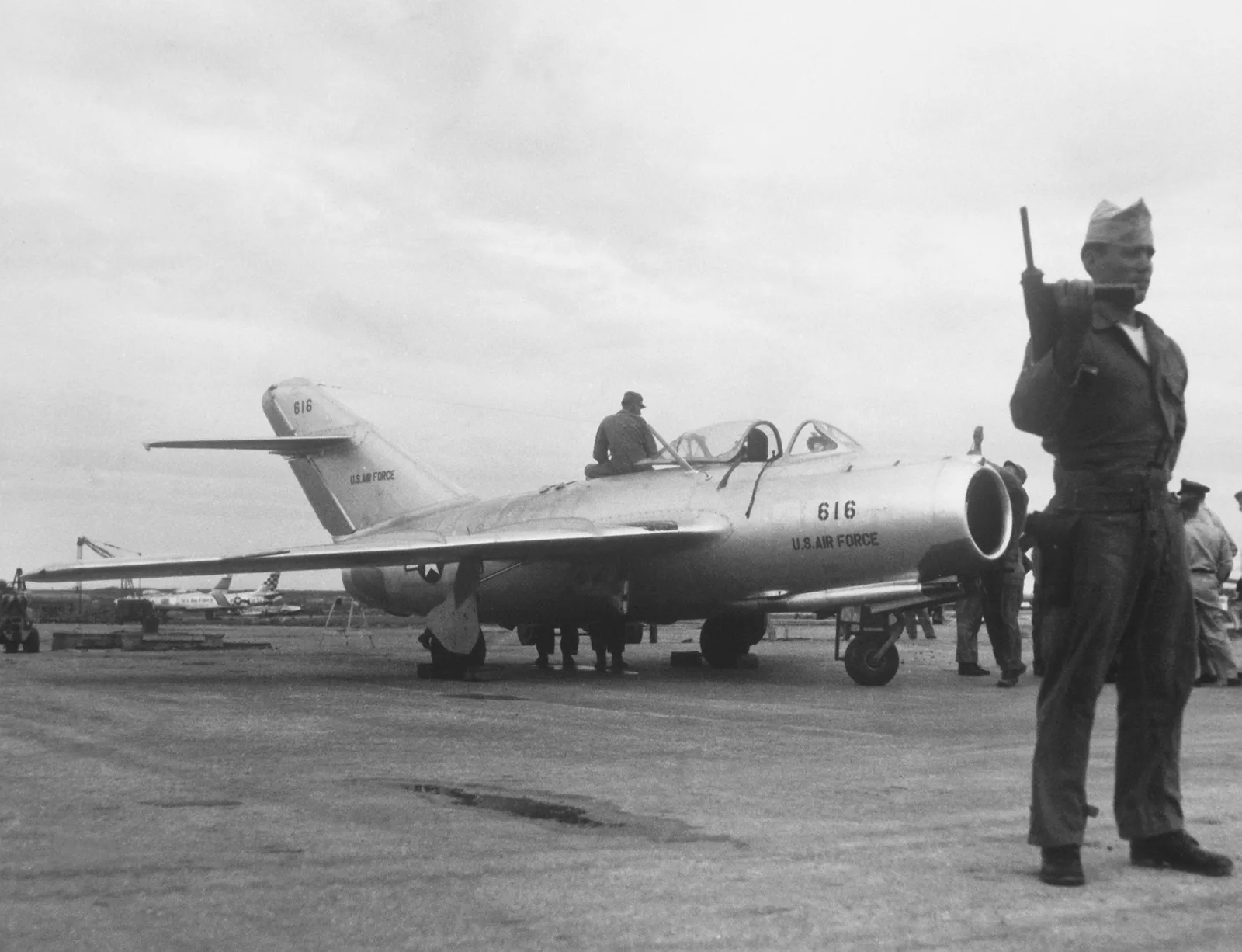 MiG-15bis 2057 at Kimpo Air Base in September 1953, with U.S. Air Force personnel nearby.